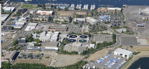 Olympia’s Budd Inlet Treatment Plant, center, is one of the few nitrogen-removing systems on Puget Sound. Photo: Washington Department of Ecology Aerial view of marina with boats, nearby water treatment plant with four circular tanks, surrounded by buildings, roads, and green space.